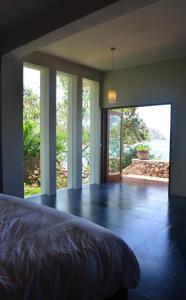 a bedroom with a bed and a large glass door at Blue Parrot in Labuan Bajo