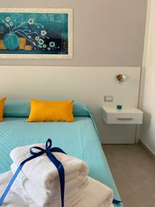 a bedroom with a bed with a towel on it at L’Angolo Chiaro in Taviano +8 photos