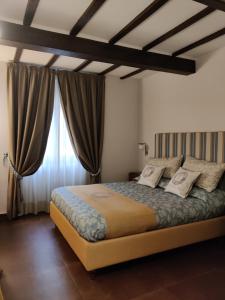 a bedroom with a large bed and a large window at L'Ospitale dei Brilli in Stia