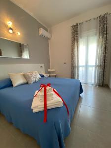 a bedroom with a blue bed with a red ribbon on it at L’Angolo Chiaro in Taviano
