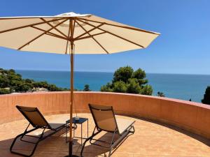 two chairs and an umbrella on a patio at Soho Boutique Castillo de Santa Catalina - Adults Recommended in Málaga