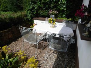 una mesa con 2 sillas y un mantel blanco en Ferienwohnung Am Lindenrain, en Mossautal