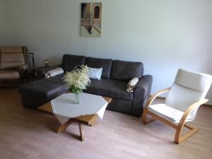 sala de estar con sofá, mesa y silla en Ferienwohnung Am Lindenrain, en Mossautal