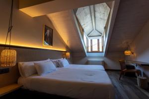 Un dormitorio con una cama grande con tragaluz. en No-Mad Green Hotel, en Molinaseca