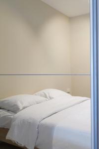ein weißes Bett in einem Zimmer mit Spiegel in der Unterkunft 'SPA' - Family Apartment with Amazing Seaview in Ostende