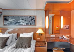 een slaapkamer met een bed en een bureau met een spiegel bij Viking Line ferry Viking XPRS - One-way journey from Helsinki to Tallinn in Helsinki