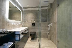 een badkamer met een glazen douche en een wastafel bij Akti Toroni Boutique Hotel in Toroni