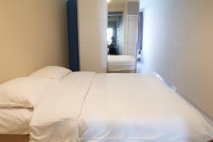 ein großes weißes Bett in einem Zimmer mit Bad in der Unterkunft 'SPA' - Family Apartment with Amazing Seaview in Ostende