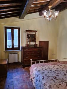 a bedroom with a bed and a dresser and a window at Casa vacanze Torre dell'orologio in Montefalco