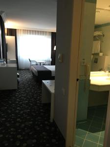 a hotel room with a bed and a bathroom at Hotel Eken Prestige in Bandırma