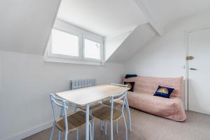 a room with a table and chairs and a couch at Appartement à 300m de la plage - Extérieur commun in Asnelles