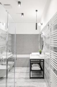 a bathroom with a tub and a sink and a toilet at Hotel Garden Court in Prague