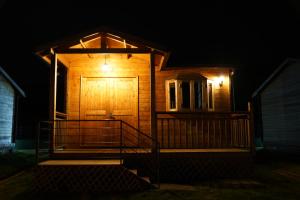 ein Holzhaus mit Holztür in der Nacht in der Unterkunft Hotel Cabañas y Mirador Secret Garden CR in Cartago