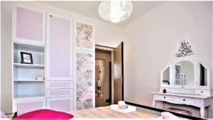 ein weißes Zimmer mit einem Tisch, einem Waschtisch und einem Spiegel in der Unterkunft Apartment Green Oasis 1 in Umag