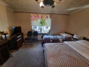 Pokój hotelowy z 2 łóżkami i biurkiem w obiekcie PENSJONAT KAPRYS w mieście Jesionka