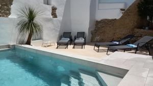 a swimming pool with four chairs and a group at Buena Vista Ronda Club in Ronda