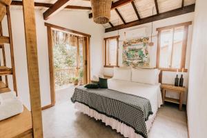 a bedroom with a bed and a window at Pousada Vila Verde Caraíva in Caraíva