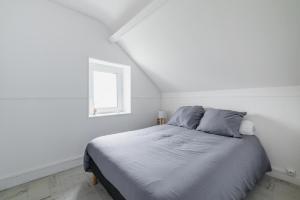 a bed in a white room with a window at Appartement à 300m de la plage - Extérieur commun in Asnelles