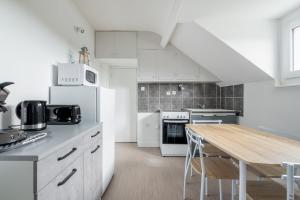 a kitchen with white appliances and a wooden table at Appartement à 300m de la plage - Extérieur commun in Asnelles