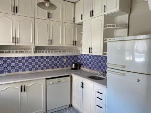 a kitchen with white cabinets and a white refrigerator at Büyükada Apart Hotel - Yeni Apart in Buyukada