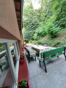 a patio with two benches and a table on a porch at Pansion Beg in Tuzla