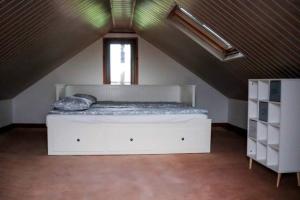 un letto bianco in una stanza con finestra di Domek na Cichej a Sandomierz