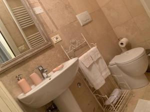 a bathroom with a sink and a toilet and a mirror at Mulino dell'Abbazia Country Resort in Corno di Rosazzo
