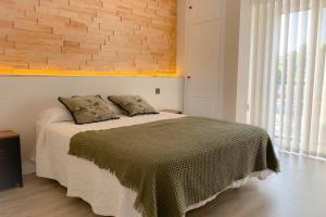1 dormitorio con cama y pared de ladrillo en Sevilla Torneo PG Apartamentos, en Sevilla
