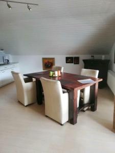 a dining room with a wooden table and chairs at Ferienwohnung / Monteurswohnung in ruhiger Waldlage in Borghees