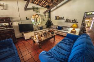 un soggiorno con un divano blu e un tavolo di Pousada da Gibinha a Campina do Monte Alegre