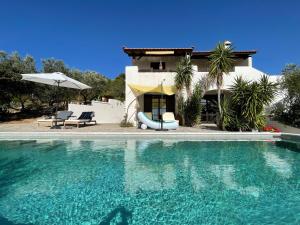 a house with a swimming pool in front of a house at SEA BREEZE STUDIO in Loutraki
