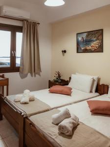 a room with two beds with towels on them at Anthoula Apartments in Kokkini Khanion