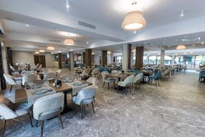 a restaurant with tables and chairs in a room at Nedei Hotel&Spa Transalpina in Martinie
