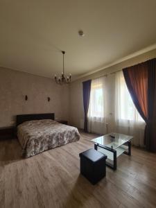 een slaapkamer met een bed en een glazen tafel bij Meldynas in Vabalninkas