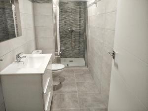 Un baño con lavabo, inodoro y ducha. en Apartamento en Avenida Quevedo, en León
