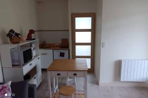 ein Wohnzimmer mit einem Tisch und einer Küche in der Unterkunft Un paradis de verdure en plein centre ville in Périgueux