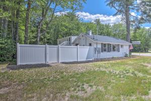 una cerca blanca frente a una casa en Charming Bridgeton Condo about 2 Mi to Long Lake!, en Bridgton