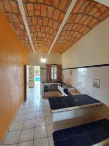 a large kitchen with a tile floor and a wooden ceiling at Real del Sol in Rincon de Guayabitos