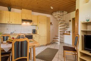 a kitchen with wooden cabinets and a spiral staircase at Hof Wagenberg Ferienwohnung 1 in Deggenhausertal