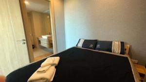a bedroom with a black bed with a mirror at Riviera Jomtien by Zoom Pattaya 1 in Jomtien Beach