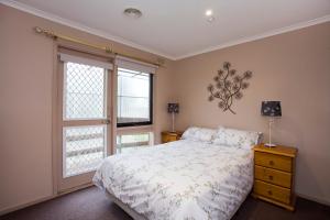 a bedroom with a bed and a window at Geelong Holiday Home in Geelong