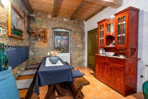 a kitchen with a table and a stone wall at Melina Heritage House in Cres