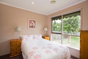a bedroom with a bed and a large window at Geelong Holiday Home in Geelong