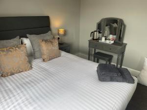 Un dormitorio con una cama con un espejo y una mesa. en The Nags Head York, en York