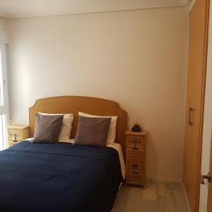 1 dormitorio con 1 cama con sábanas azules y mesita de noche en Aleksandra Apartament Sant Pere en El Campello