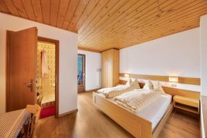 1 dormitorio con 2 camas y techo de madera en Grödnerhof Almöhi en Brie