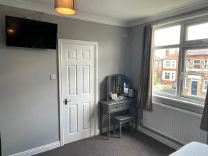 Habitación con puerta, escritorio y ventana en The Nags Head York, en York