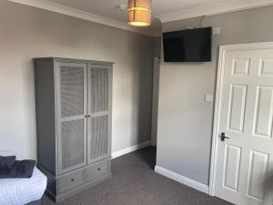 1 dormitorio con 1 cama, TV y armario en The Nags Head York, en York