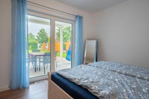 um quarto com uma cama e uma varanda com uma mesa em Ferienhaus „Linde 1“ em Winsen