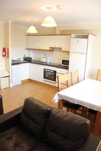 a kitchen and dining room with a couch and a table at Tralee Town Centre Apartments in Tralee